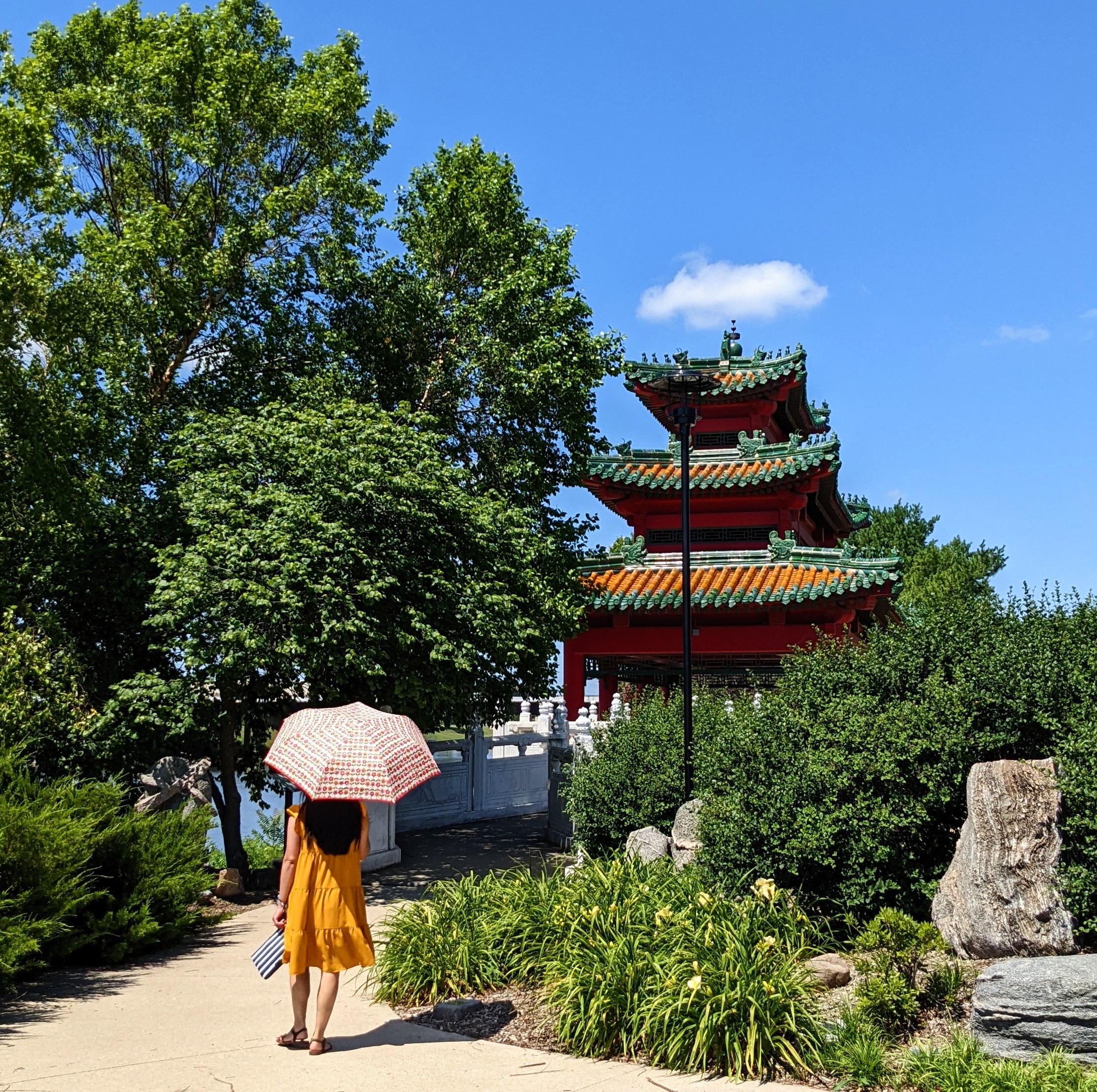 Woman with umbrella standing in front of a pagoda